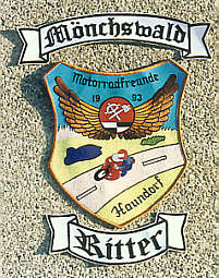 Wappen mit zwei Schriftzügen auf Bannern oben und unten